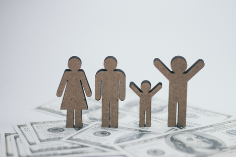 Stick figures of people standing on money