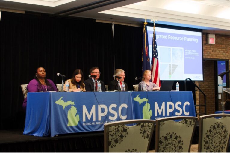 Members of the Michigan Public Service Commission sit with an administrative law judge and staff member for a public hearing on Integrated Resource Planning.